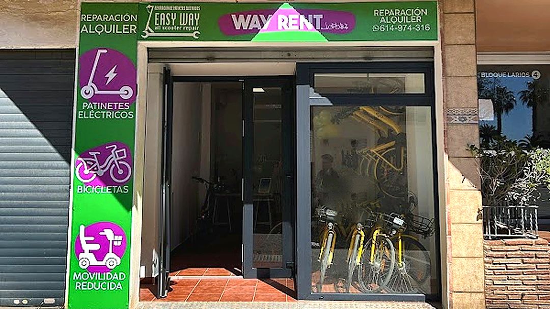 Fachada de la tienda WayRent con el cartel verde y morado